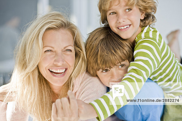 Frau lächelt mit ihren beiden Söhnen
