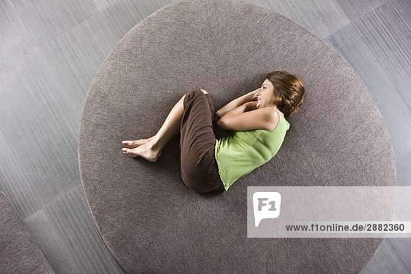 Woman lying on a round sofa