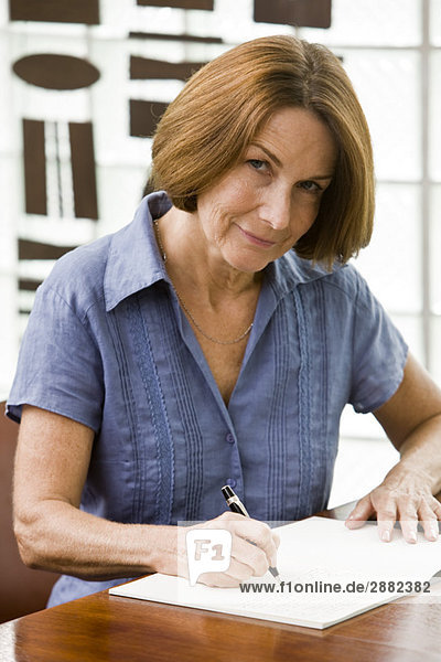 Porträt einer Frau  die in ein Notizbuch schreibt