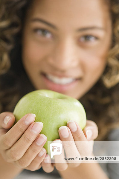 Porträt eines Mädchens mit grünem Apfel und lächelndem Gesicht