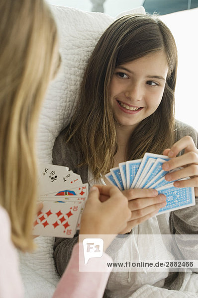 Zwei Mädchen spielen Karten