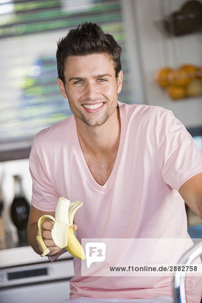 Porträt eines Mannes,  der eine Banane isst