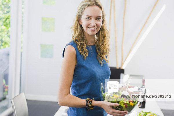Frau hält eine Schüssel Salat und lächelt