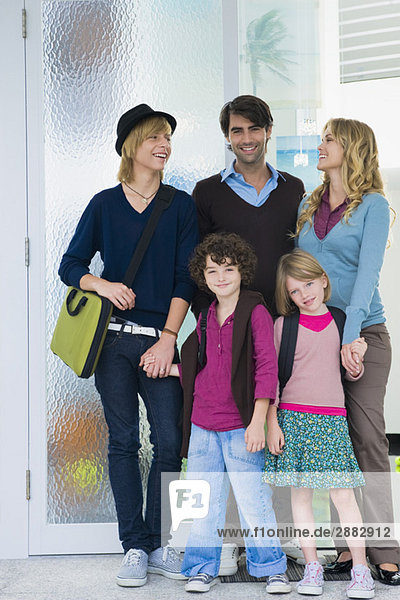 Pärchen mit ihren Kindern und einem Kindermädchen vor der Haustür