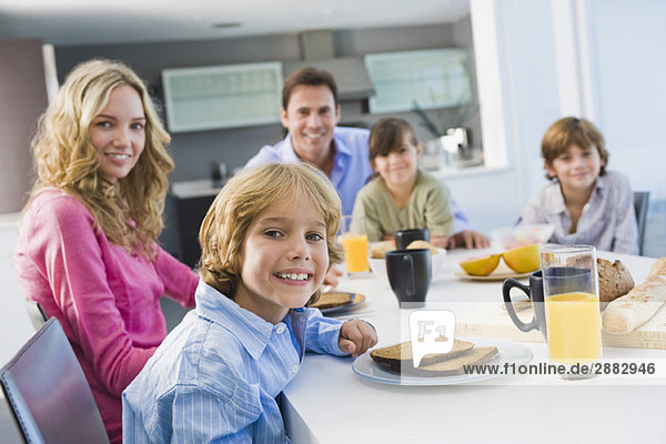 Porträt einer Familie beim Frühstücken und Lächeln