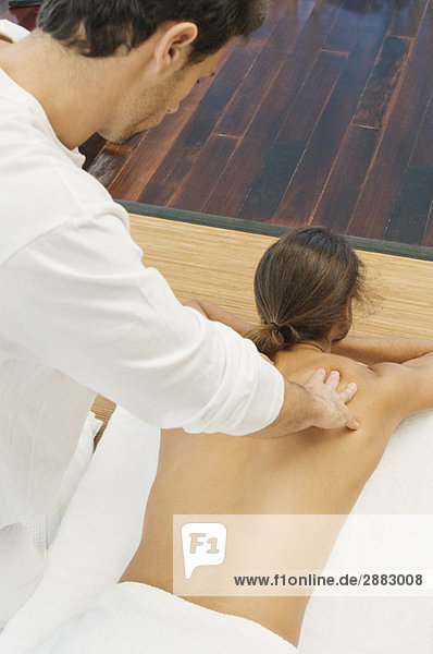 Mann erhält eine Rückenmassage von einem Massagetherapeuten