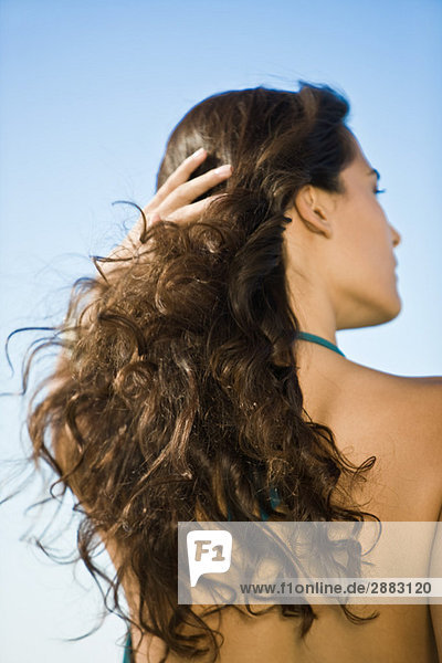 Rear view of a woman with her hand in her hair