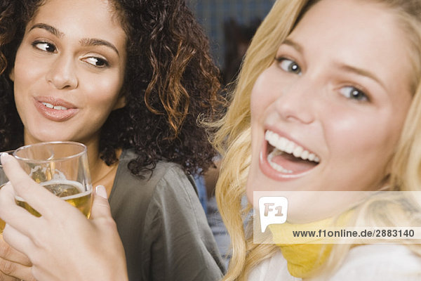 Zwei Frauen genießen Getränke auf einer Party