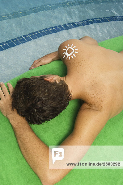 Hochwinkelansicht eines Mannes beim Sonnenbaden am Pool