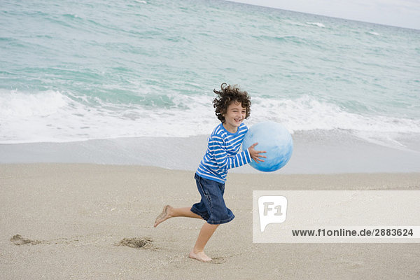 Junge spielt am Strand