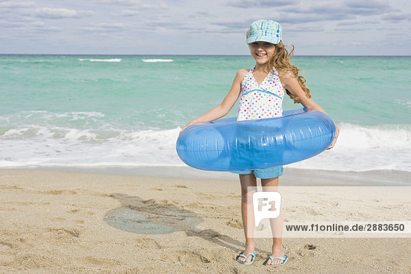 Girl wearing an inflatable ring on the beach