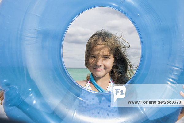 Girl looking through an inflatable ring