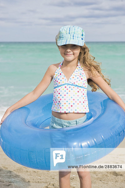 Girl wearing an inflatable ring on the beach