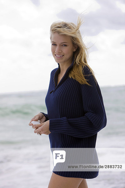 Woman holding a shell on the beach