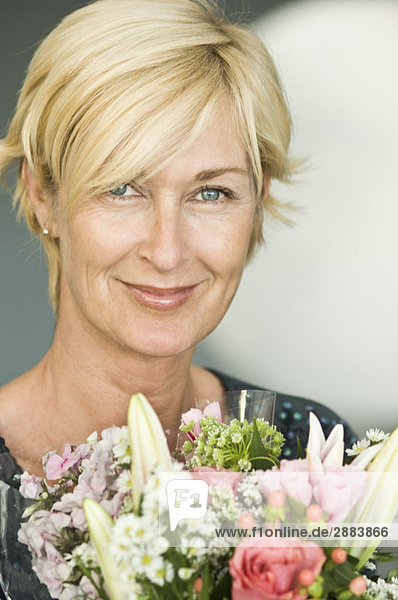 Portrait of a woman smiling with a bouquet of flowers
