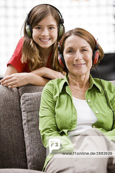 Woman and her granddaughter listening to headphones
