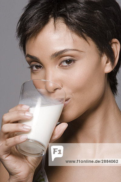 Porträt einer Frau  die Milch aus einem Glas trinkt
