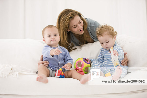 Woman playing with her son and daughter on a couch