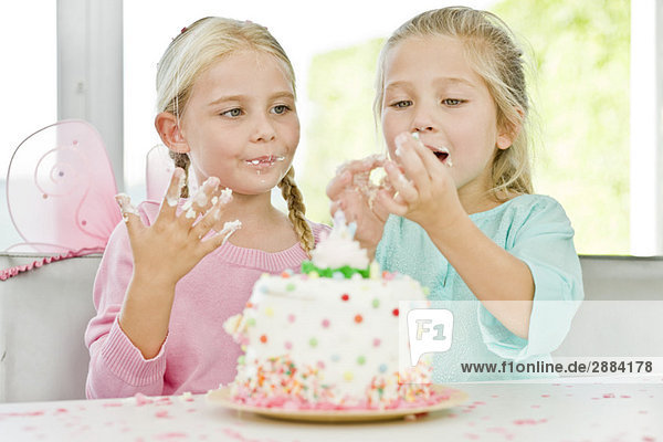 Two girls eating birthday cake