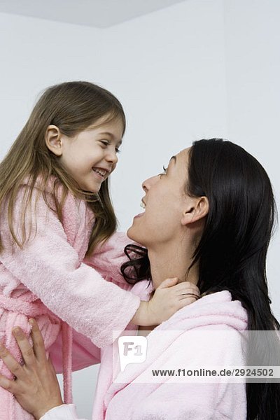Eine Mutter und Tochter in rosa Bademänteln.
