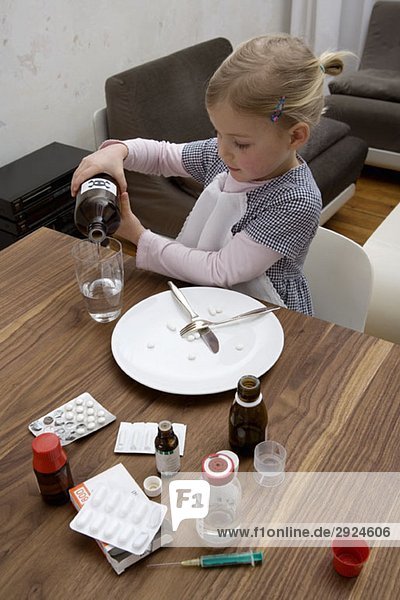 A young girl pouring a toxic substance into a glass and surrounded by medicines