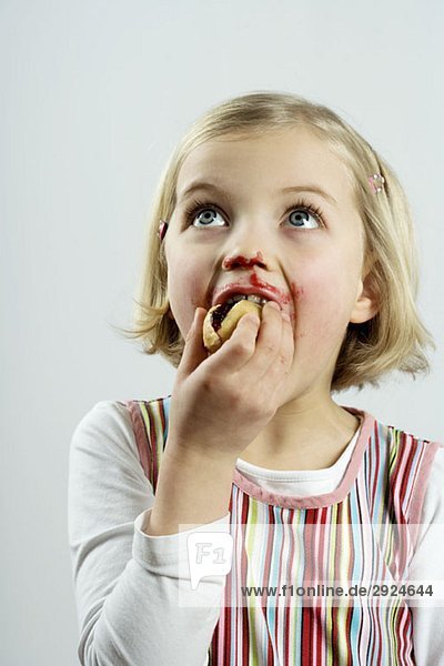 A young girl eating bread and jam