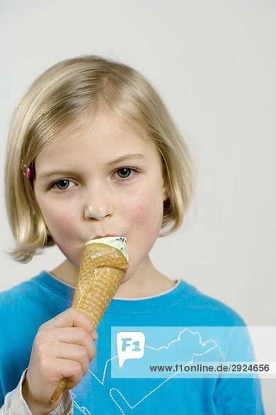 A young girl eating an ice cream cone