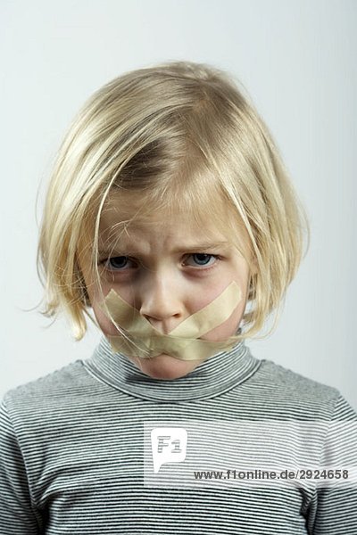 A young girl with tape over her mouth