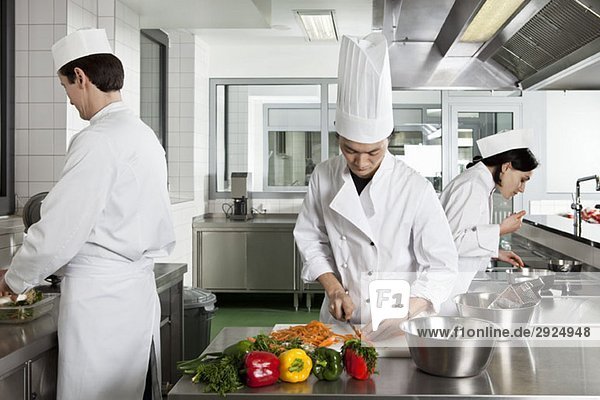 Three chefs working in a commercial kitchen