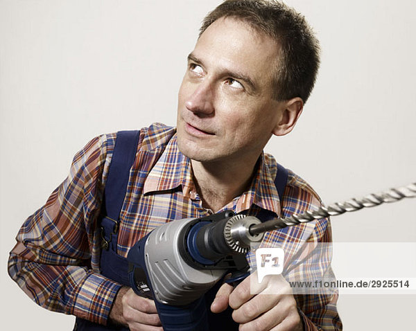 A man holding a large drill