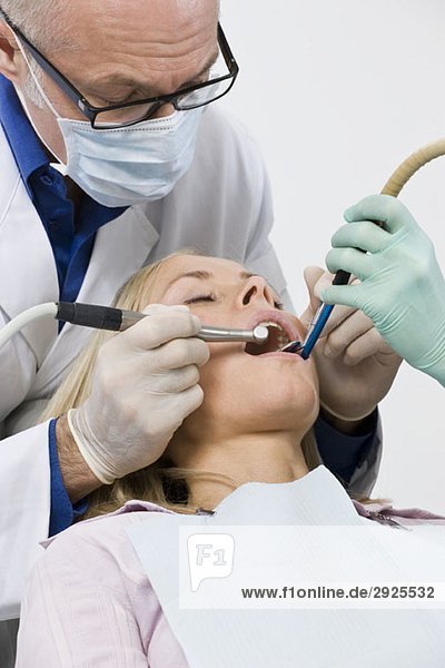 Ein Zahnarzt untersucht den Mund einer Frau