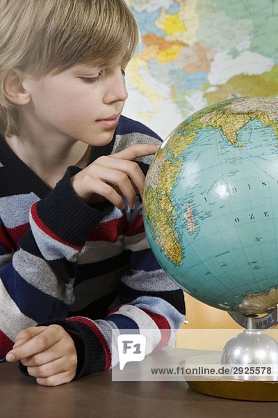Ein Schuljunge schaut auf einen Globus