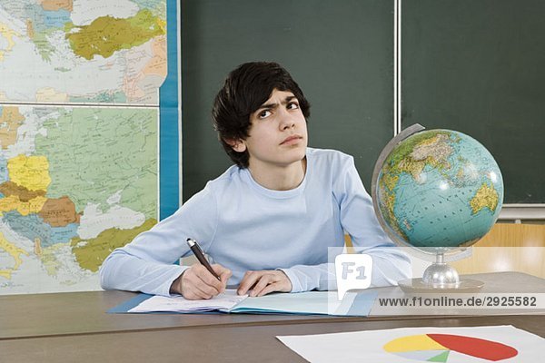Ein Schuljunge schaut auf und runzelt die Stirn.
