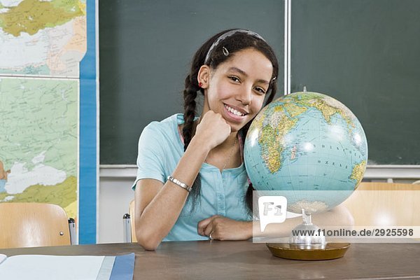 Porträt einer Schülerin in der Nähe eines Globus
