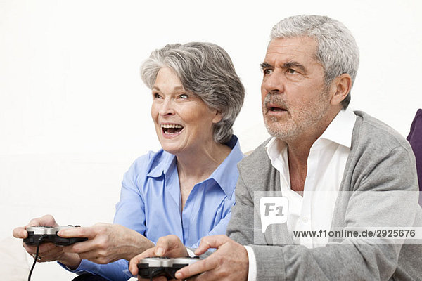 A senior man and senior woman playing a video game