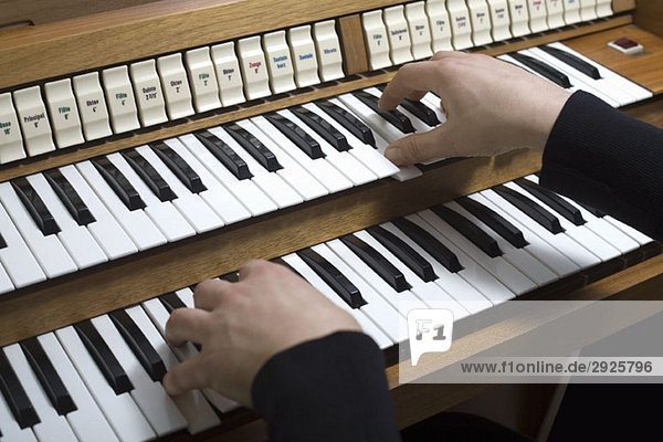 Menschliche Hände  die eine Orgel spielen
