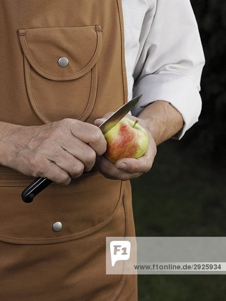 Detail of a man cutting an apple