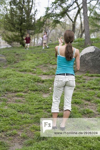 A mother beckoning her children in Central Park  New York City