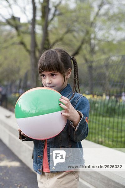 Ein junges Mädchen hält einen aufblasbaren Ball im Central Park  New York City.