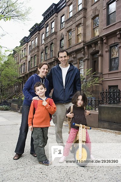 A family standing in front of a row of brownstone townhouses  Brooklyn  New York City