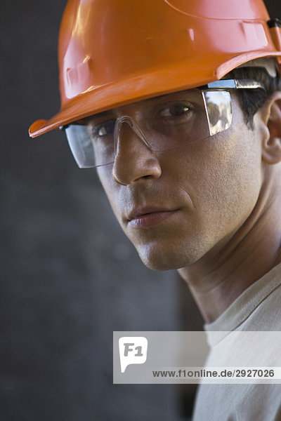 Bauarbeiter mit Schutzhelm  Schutzbrille mit Blick auf die Kamera
