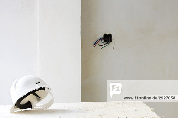Schutzhelm auf Tisch im unfertigen Raum