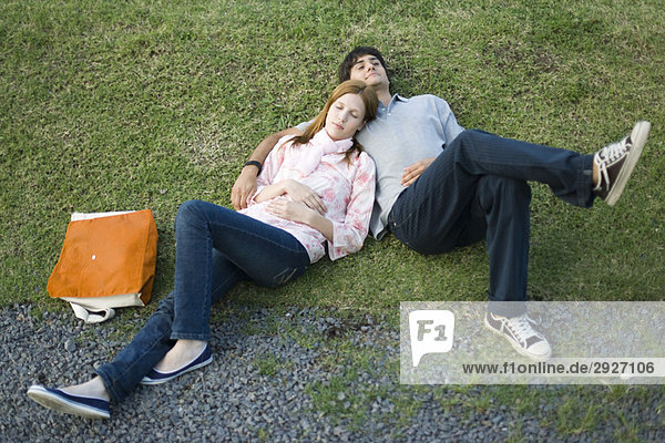 Junges Paar zusammen auf Gras liegend  hoher Blickwinkel