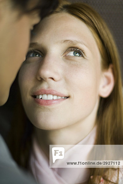 Young woman face to face with man  looking up hopefully  smiling