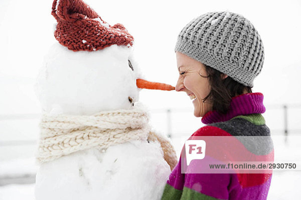 woman nose to nose with snowman
