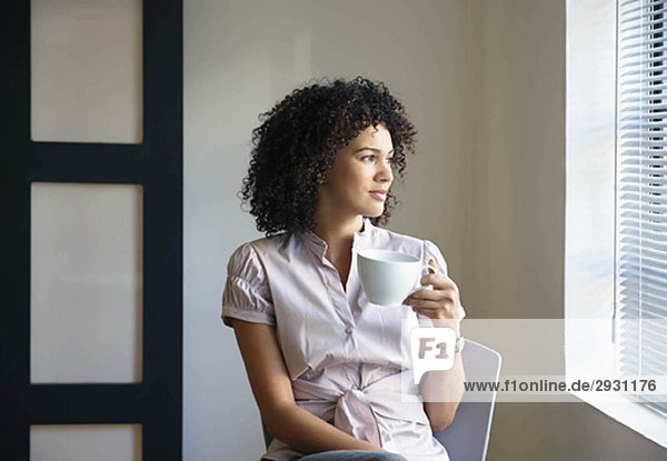 Young woman with cup  thinking