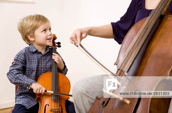 Frau und Junge spielen Cello