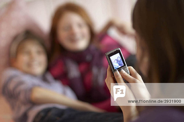 Teenage girls taking photo on phone