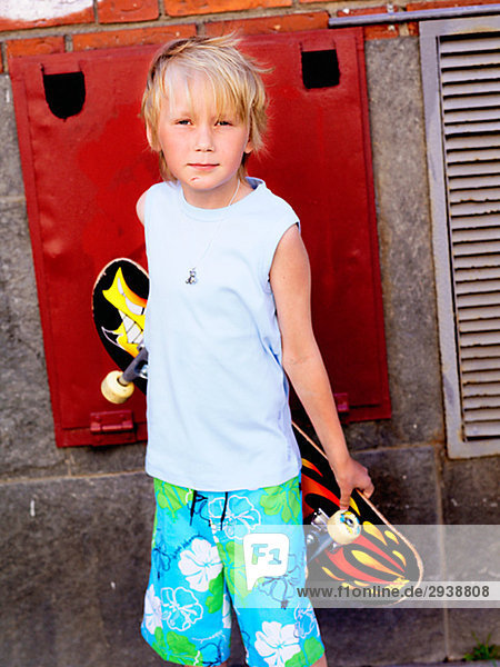 Junge mit einem Skateboard gegen eine Wand Schweden.
