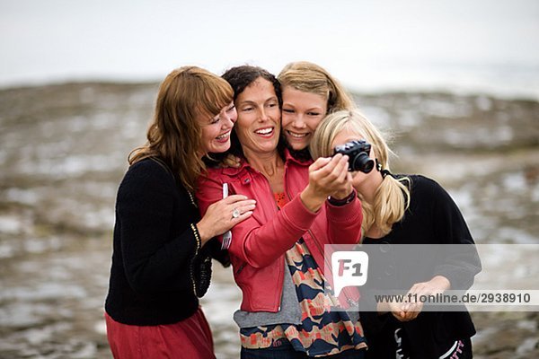 Zwei Frauen und zwei Mädchen Blick auf ein Bild in der Kamera Schweden.